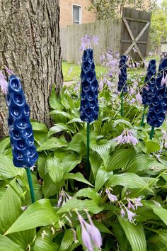 Handmade dark blue ceramic flowers surrounded by hosta plants in bloom. Ceramic Yard Art, Blue Lupine, Pottery Flowers, Garden Totem, Exquisite Gardens, Garden Sculptures, Garden Pottery, Flower Sculptures, Garden Yard Ideas