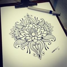 a drawing of a flower on paper next to a pen