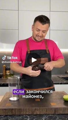 a man in an apron is holding a chocolate donut