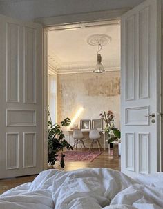 an open door leading to a bedroom with white walls