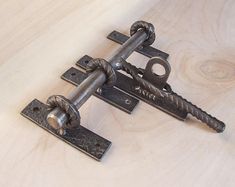 an old metal door handle on a wooden surface with screws and nails attached to it