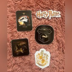 harry potter coasters are shown on a pink carpet with hogwart's crest