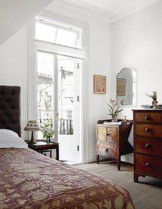 a bed room with a neatly made bed and a dresser