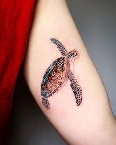 a small turtle tattoo on the arm