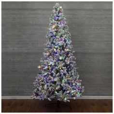 a white christmas tree with multicolored lights on it's top and bottom