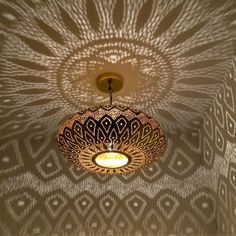 the light fixture is hanging from the ceiling in front of a wallpapered pattern