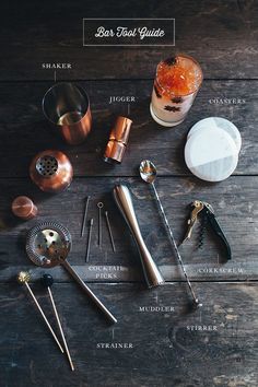 the contents of a cocktail shaker sitting on top of a wooden table next to utensils