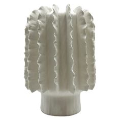 a white vase with ruffles on it's sides is shown in front of a white background