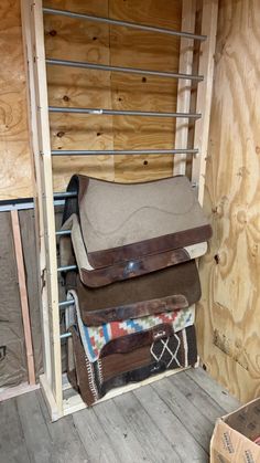 the inside of a storage room filled with lots of bags and saddles in it