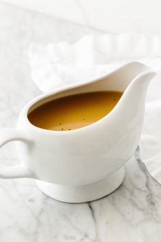 a white gravy dish on a marble table