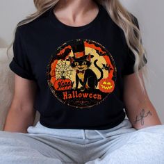 Vintage Retro Halloween Cat t shirt, Nostalgic retro gift for her, Halloween Kitty Cat Lover gift tee for mom 🌟 **Step into the past with our Retro Halloween Cat Unisex Jersey Tee 🌟 Embrace the charm of yesteryear with our  Retro Halloween Cat Unisex Jersey Short Sleeve Tee. This classic tee is not just a piece of clothing; it's a nostalgic journey wrapped in soft cotton and adorned with adorable vintage baby animals. Perfect for all ages, this tee fits like a well-loved favorite and will make you fall in love over and over again. ✨ **Quality You Can Feel Made with 100% Airlume combed and ring-spun cotton, our lightweight fabric (4.2 oz/yd² or 142 g/m²) is a dream to wear. The breathable material is easy to layer, making it ideal for both active and leisure wear. The ribbed knit collars, Black Vintage Top Gift, Vintage Black Top As Gift, Vintage Black Top Gift, Halloween Graphic Print Top As Gift, Novelty Black T-shirt As Gift, Novelty Black T-shirt As A Gift, Gift Retro Black T-shirt, Novelty Black T-shirt For Gift, Halloween Graphic Tee With Cat Design