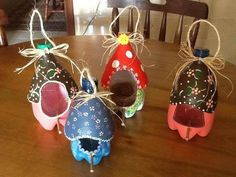 four decorated wine bottles sitting on top of a wooden table