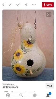 a ceramic birdhouse with sunflowers painted on it