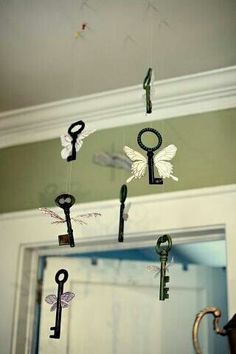 several keys are hanging from the ceiling in front of a mirror