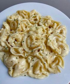 a white plate topped with pasta covered in sauce