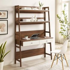 a desk with a laptop on it in front of a wall mounted shelving unit