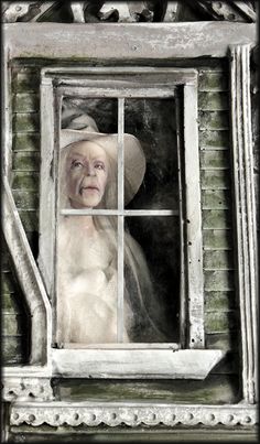 an old woman is looking out the window