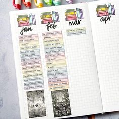 an open planner book with markers and pens on the side, next to it is a cup of colored crayons