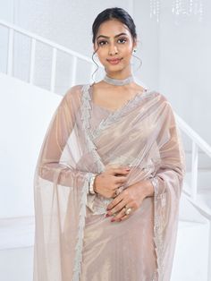 Introducing a mesmerizing ensemble that epitomizes timeless sophistication – the beige organza saree adorned with intricate Swarovski work all over and a luxurious heavy handwork border. Crafted from ethereal organza material, this saree boasts a delicate texture and a graceful drape that exudes elegance with every movement. 
Accompanying the saree is a matching beige organza blouse intricately detailed with zircon work. The seamless coordination of color between the saree and blouse create Engagement Gown, Organza Material, Lehenga Crop Top, Saree And Blouse, Lehenga Choli Wedding, Floral Lehenga, Party Wear Lehenga Choli, Reception Gown, Bollywood Lehenga