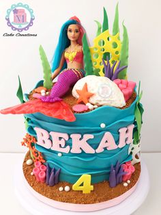 a birthday cake with a doll sitting on top of it and under the words bekah