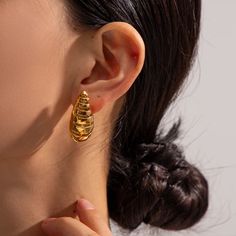 Elevate your style with the enchanting Corine Spiral Drop Earrings. Crafted with precision, these earrings feature a mesmerizing spiral design that effortlessly adds a touch of sophistication to any ensemble. The delicate drop silhouette gracefully enhances your neckline, making it a perfect accessory for both casual and formal occasions. Embrace timeless elegance with the Corine Spiral Drop Earrings and let your unique sense of fashion shine. Item Details: 18kt Gold Plated Stainless Steel Water Swirl-shaped Earrings With Ear Wire, Elegant Spiral Metal Earrings, Elegant Swirl Shaped Metal Jewelry, Elegant Spiral Wrap Earrings, Spiral Single Wrap Earring, Spiral Wrap Pierced Earrings, Elegant Swirl Hoop Earrings As Gift, Swirl Earrings For Pierced Ears, Elegant Swirl Shaped Pierced Earrings