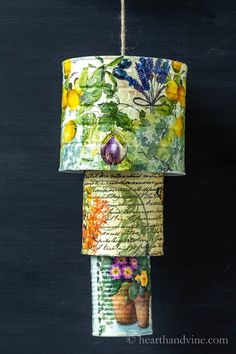 three rolls of fabric hanging from a rope with flowers and plants printed on them,