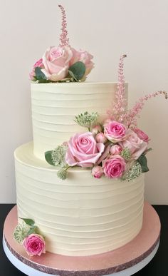 a three tiered cake with pink flowers on top