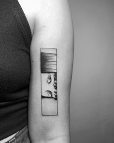 a woman with a black and white photo tattoo on her arm, showing the reflection of two people in a window