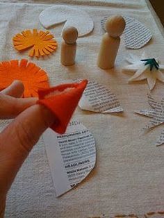 someone is making paper flowers out of old book pages and other crafting supplies on a table