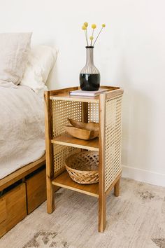 a wooden table with baskets on it next to a bed