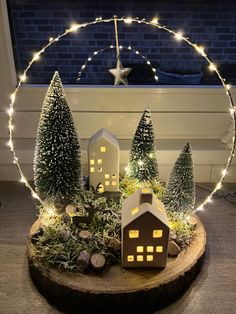 a christmas scene with houses and trees in the center of a circular decoration made out of wood