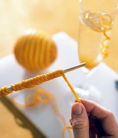 a person is holding a yellow stick in front of some honeycombs and wine glasses