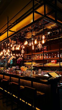 a bar with lots of lights hanging from the ceiling