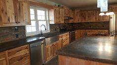 a large kitchen with wooden cabinets and stainless steel appliances in it's center island