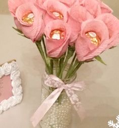 pink flowers in a vase next to a heart shaped frame