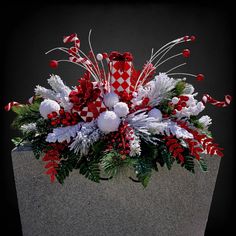 a vase filled with red, white and green christmas decorations on top of a table