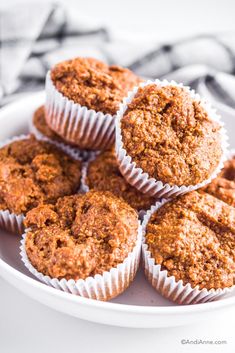 several muffins on a white plate sitting on a table