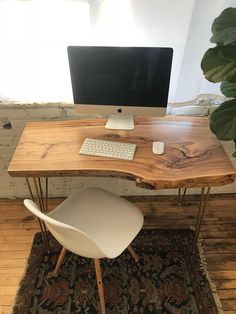 a wooden desk with a computer on it and a chair in front of the desk