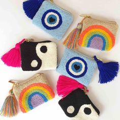 four small purses with different designs and tasselled handles, one has a colorful eye on it