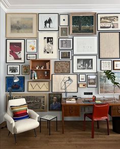 a room with many pictures on the wall and a chair next to a desk in front of it