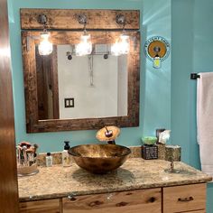 a bathroom with blue walls and a wooden bowl on the sink counter in front of a mirror