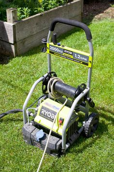 a lawn mower sitting in the grass next to a garden