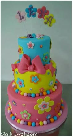 a three tiered cake decorated with flowers and butterflies