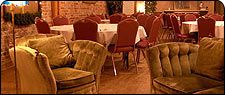 an image of a restaurant setting with tables and chairs set up for formal dinner or party