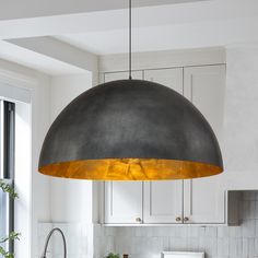 a kitchen with white cabinets and a large light fixture hanging from the ceiling above it