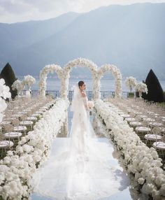 the bride is walking down the aisle covered in flowers