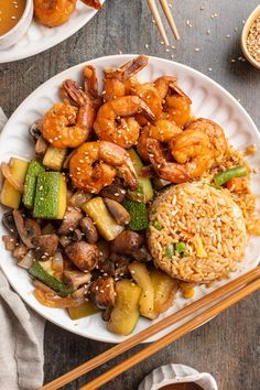 shrimp, zucchini, and rice on a white plate with chopsticks