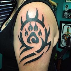 a woman's arm with a tattoo on it and a dog paw in the center