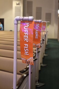 rows of pews with orange banners on them in a church auditorium or meeting room