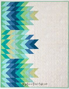 a blue and green quilt with an arrow design